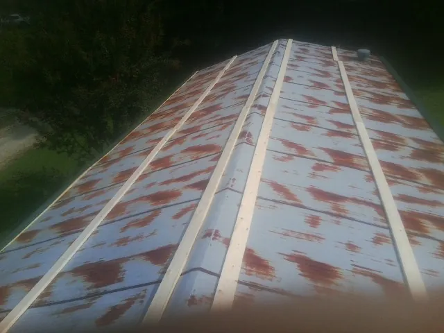 Rusted metal roof panels with new wood purlins before replacement — Storm Damage Roof Repair in Micanopy by Roofing Brothers